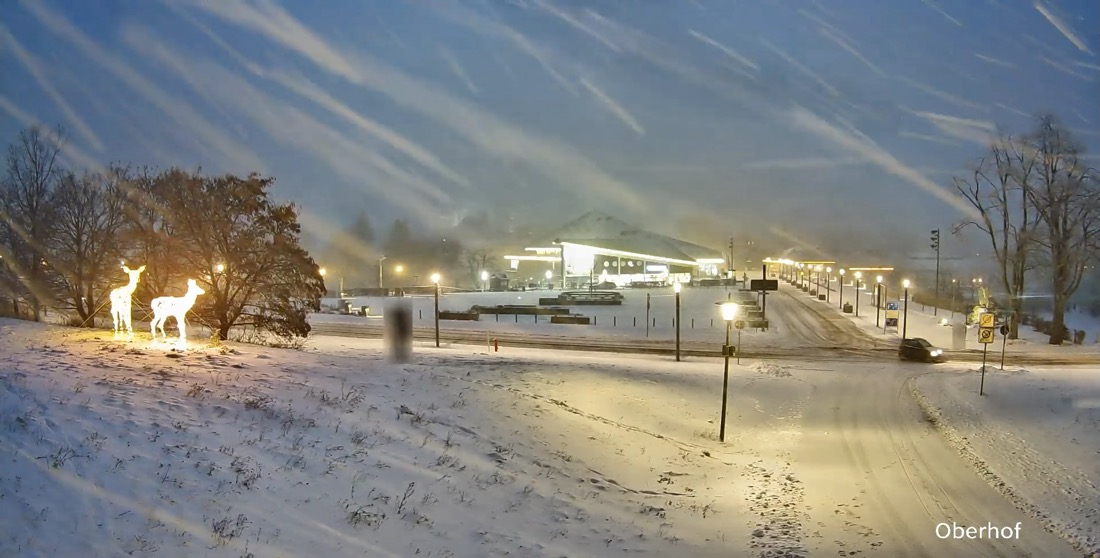 Derselbe Blick bei Nacht und Schneetreiben, ein Auto auf der Straße.